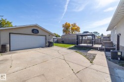 Detached garage with a two-car overhead door, concrete driveway, wood deck with gazebo, and fenced backyard - 