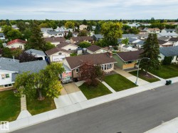 Paved street with concrete sidewalks and mature trees throughout the neighborhood - 