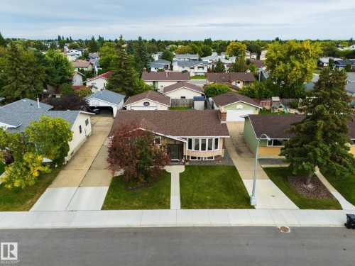 Single-story residence featuring a bay window, asphalt shingle roof, and a mature front yard tree - 17311 107 Street Nw, Edmonton, AB 
