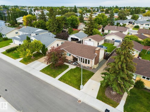 Neutral-toned exterior with a prominent bay window and brick chimney accent - 17311 107 Street Nw, Edmonton, AB 