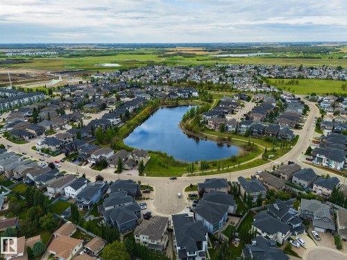 Residential community with a central water feature, surrounding green spaces, and paved streets - 17311 107 Street Nw, Edmonton, AB 