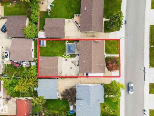 Expansive backyard featuring a manicured lawn, concrete patio, and stone paver pathway - 17311 107 Street Nw, Edmonton, AB 