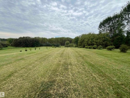 Expansive green lawn extending to a dense perimeter of mature trees - #15 2319 Twp Road 524, Rural Parkland County, AB 