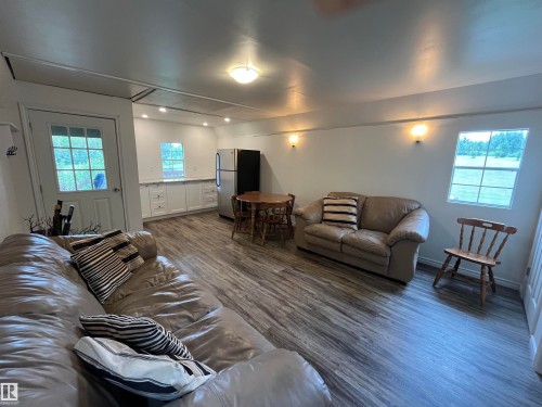 Wood-finish flooring throughout, white cabinetry with countertops, stainless steel refrigerator, and recessed lighting - #15 2319 Twp Road 524, Rural Parkland County, AB 