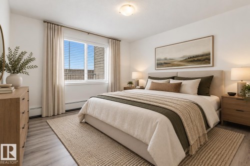 Room featuring wood-finish flooring, a neutral color palette, and a large window with white trim - #109 4309 33 St, Stony Plain, AB 
