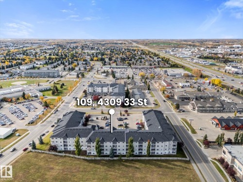 Aerial perspective of a multi-story residential complex featuring paved surface parking, balcony access, and proximity to major thoroughfares - #109 4309 33 St, Stony Plain, AB 