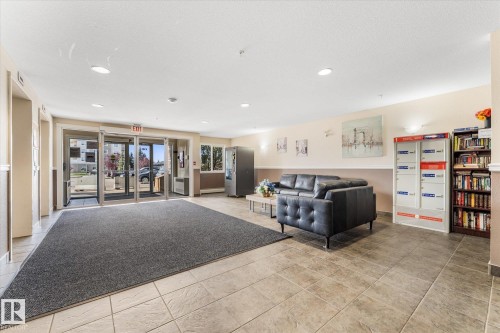 Building lobby featuring recessed lighting, tile flooring, secure parcel lockers, and glass-paneled entry doors - #109 4309 33 St, Stony Plain, AB 