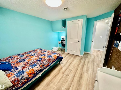 Wood-finish flooring, interior room with recessed built-in shelving, and white paneled doors - 4723 105 Street Nw, Edmonton, AB 