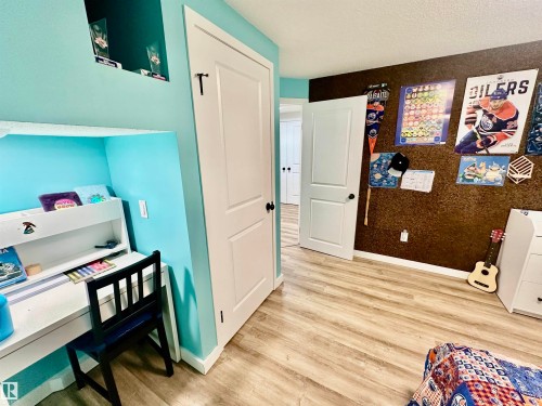 Room interior featuring wood-finish flooring, two-panel interior doors, and a built-in recessed wall niche - 4723 105 Street Nw, Edmonton, AB 