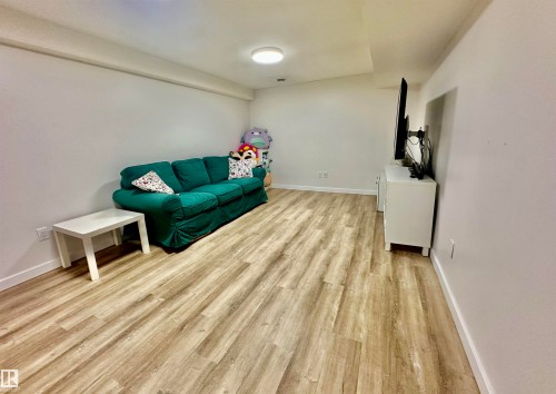 Interior space featuring wood-finish flooring, white walls, and a flush-mount ceiling light - 4723 105 Street Nw, Edmonton, AB 