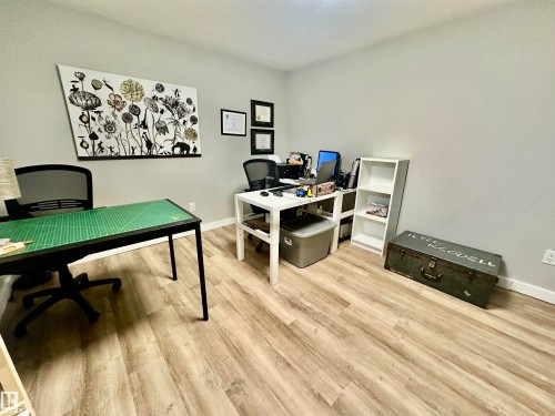Neutral-toned room featuring wood-finish flooring - 4723 105 Street Nw, Edmonton, AB 