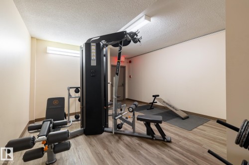 Interior room featuring wood-finish flooring and linear overhead lighting - #1304 10160 116 St Nw, Edmonton, AB 