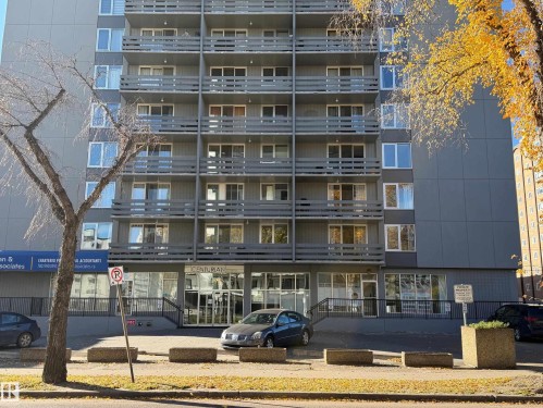 Mid-rise residential building exterior featuring stacked balconies, large windows, and a glass-paneled ground floor entrance - #1304 10160 116 St Nw, Edmonton, AB 