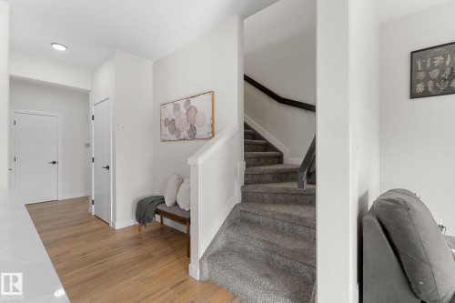 Wood-finish flooring, recessed lighting, white interior doors, and a carpeted staircase with a dark handrail - 1142 Goldfinch Crescent Nw, Edmonton, AB 