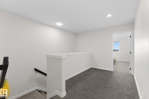 Carpeted landing with recessed lighting, white walls, and a white half-wall railing - 1142 Goldfinch Crescent Nw, Edmonton, AB 