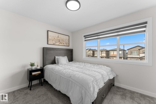 Wall-to-wall carpeting, a large window with roller shades, and a flush-mount ceiling light - 1142 Goldfinch Crescent Nw, Edmonton, AB 