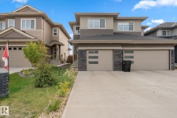 Modern exterior with multi-toned siding, stone accents, and a concrete driveway - 