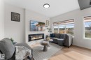 Shiplap accent wall with an electric fireplace, wood-finish flooring, recessed ceiling lighting, and multiple windows - 1142 Goldfinch Crescent Nw, Edmonton, AB 