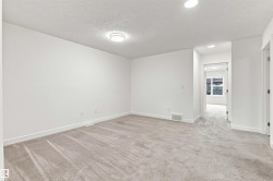 Neutral-toned carpeting, recessed lighting, and a flush-mount ceiling fixture illuminate this expansive room - 