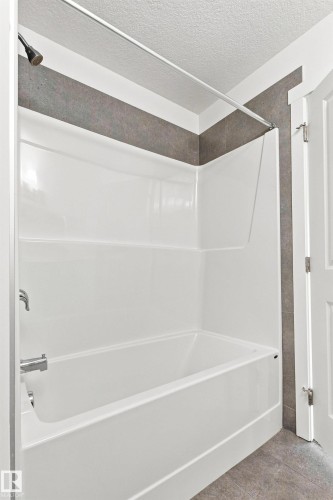 White fiberglass tub and shower combination with a bronze shower head and chrome fixtures - 22019 82 Avenue Nw, Edmonton, AB 