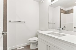 White vanity with an integrated rectangular sink, chrome faucet, and expansive mirror - 