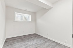 Recessed window with white trim, wood-finish flooring, white walls, and bright overhead lighting - 