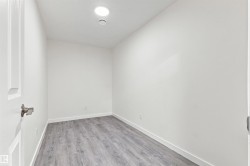 Recessed ceiling lighting, wood-finish flooring, white walls, and white trim - 