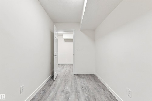 Light wood-finish flooring, white walls, and a white interior door - 22019 82 Avenue Nw, Edmonton, AB 
