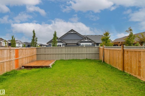 Expansive backyard featuring a lush lawn, wood deck, and perimeter fencing - 22019 82 Avenue Nw, Edmonton, AB 