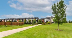 Townhome community with a gravel pathway and large grassy areas - 