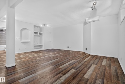 Open floor plan featuring wood-finish flooring, recessed lighting, built-in shelving, and two arched wall niches - 876 Twin Brooks Close Nw, Edmonton, AB 