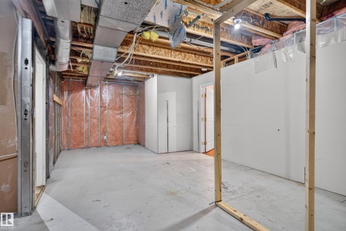 Unfinished interior space featuring exposed wood framing, concrete flooring, metallic ductwork, and installed insulation panels - 876 Twin Brooks Close Nw, Edmonton, AB 