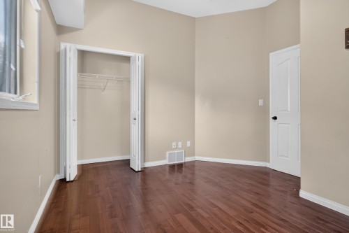 Wood-finish flooring, vaulted ceiling, double-door closet, and six-panel interior door - 876 Twin Brooks Close Nw, Edmonton, AB 
