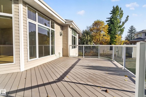 Spacious exterior deck featuring composite decking, white aluminum railing with glass panel inserts, and expansive windows - 876 Twin Brooks Close Nw, Edmonton, AB 