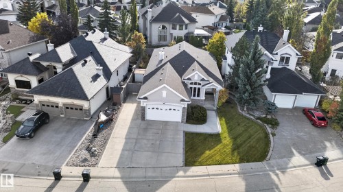 Multi-level residence featuring a neutral-toned exterior, concrete driveway, attached garage, stone facade accents, and a front lawn - 876 Twin Brooks Close Nw, Edmonton, AB 