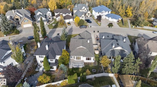 Aerial perspective of a detached residential property featuring a multi-gabled shingle roof, rear-facing elevated deck, and a landscaped backyard with mature coniferous and deciduous trees - 876 Twin Brooks Close Nw, Edmonton, AB 