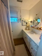 White vanity with black hardware, integrated sink, and wall-mounted light fixture - 