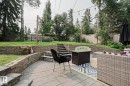 Multi-level backyard featuring a paver patio, stone retaining walls, and a manicured lawn - 5 Gilmore Crescent, St. Albert, AB 