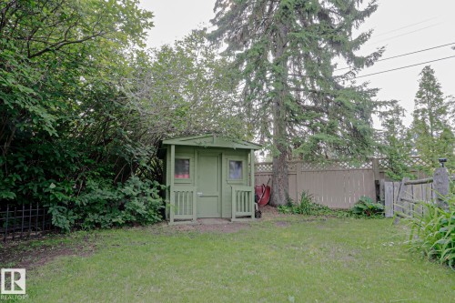 Green-painted storage shed with windows and a small porch - 5 Gilmore Crescent, St. Albert, AB 