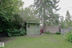 Green-painted storage shed with windows and a small porch - 