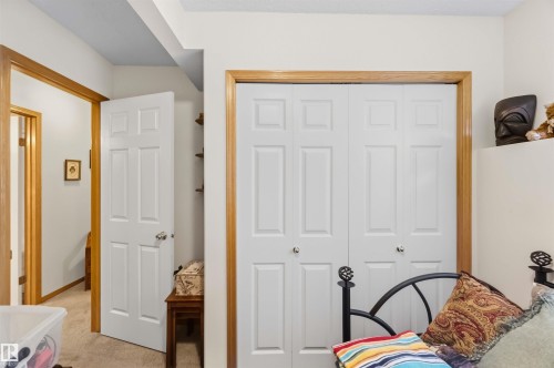 White six-panel interior doors and bi-fold closet doors framed in natural wood trim - 497 Kananaskis Drive, Devon, AB 