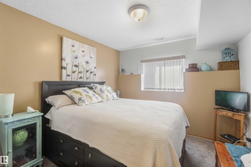Bedroom featuring neutral wall paint, carpeted flooring, a recessed window ledge, and a ceiling-mounted flush light fixture - 497 Kananaskis Drive, Devon, AB 