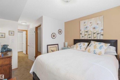 Neutral-toned interior space featuring beige accent wall, multi-panel doors, and flush-mount ceiling light fixtures - 497 Kananaskis Drive, Devon, AB 