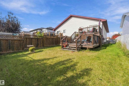 Multi-level wood deck featuring stairs and railings, enclosed by wood privacy fencing with lattice detail - 497 Kananaskis Drive, Devon, AB 
