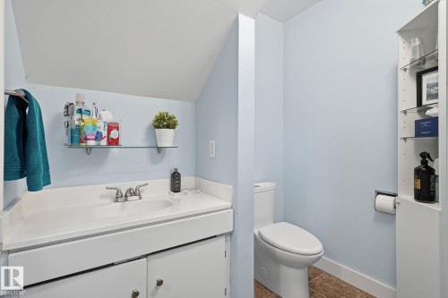 White vanity with an integrated sink and chrome faucet, glass shelf, and a built-in vertical storage cabinet - 5340 38A Avenue Nw, Edmonton, AB 