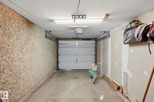 Single-vehicle garage with concrete flooring, fluorescent overhead lighting, and an automatic overhead door - 5340 38A Avenue Nw, Edmonton, AB 