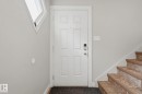 White paneled entry door with smart lock hardware - 5340 38A Avenue Nw, Edmonton, AB 