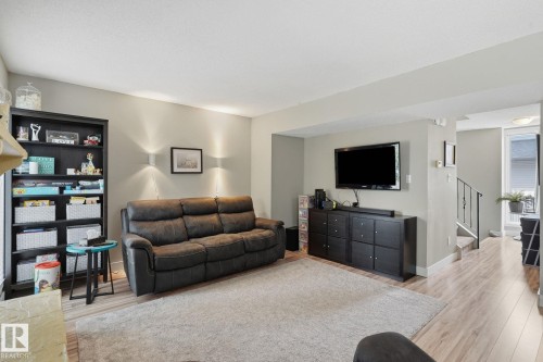 Recessed ceiling, wood-finish flooring, staircase with metal railing, built-in shelving, wall-mounted sconces - 5340 38A Avenue Nw, Edmonton, AB 