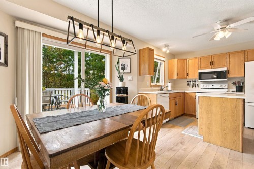 Kitchen with wood-finish flooring, light wood cabinetry, and white appliances - 51064 Rge Rd 222, Rural Strathcona County, AB 