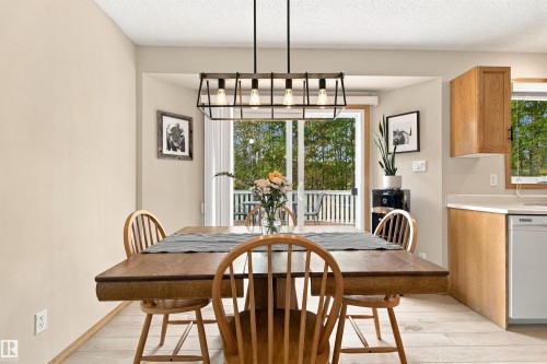 Light wood-finish flooring with a linear chandelier - 51064 Rge Rd 222, Rural Strathcona County, AB 